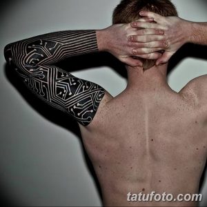 Фото татуировки в стиле биомеханика, покрывающей всю руку и плечо. Изображены сложные механические детали, провода и микросхемы, создающие эффект кибернетического рукава.